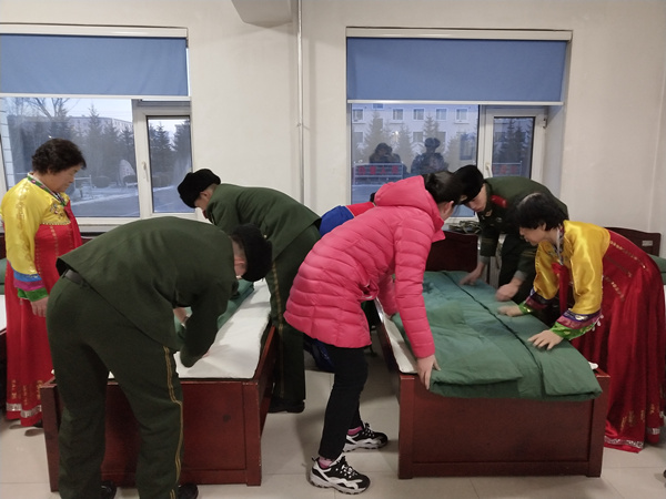 兵妈妈与少先队员一起为新兵整理床铺
